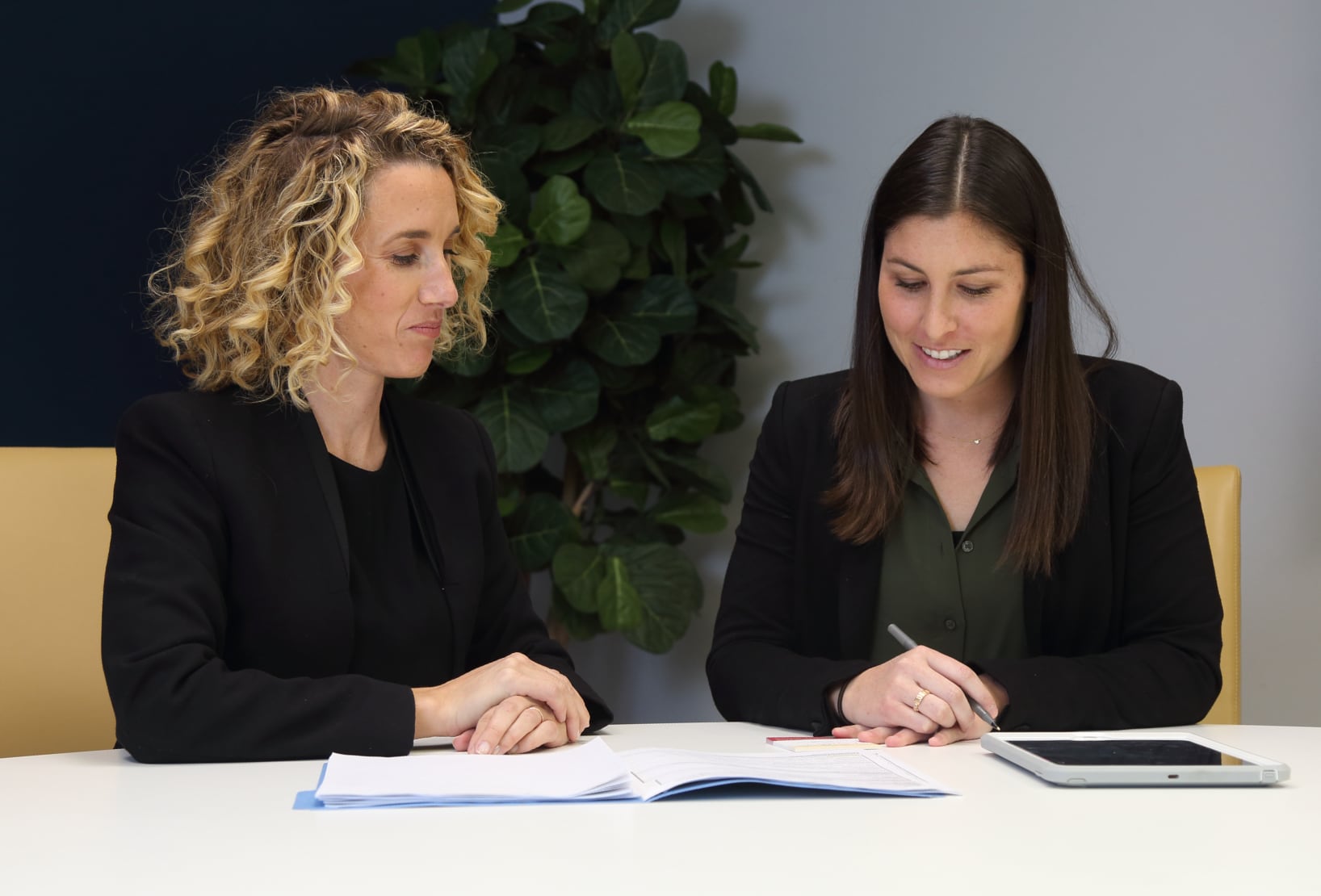 Associate Directors Chantelle Rice Collin and Lindsey Shomer sitting at a conference table, developing patient engagement and clinic performance metrics.