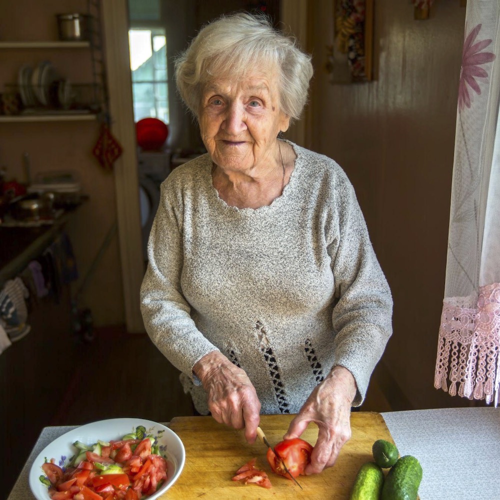 Older woman chopping food in kitchen