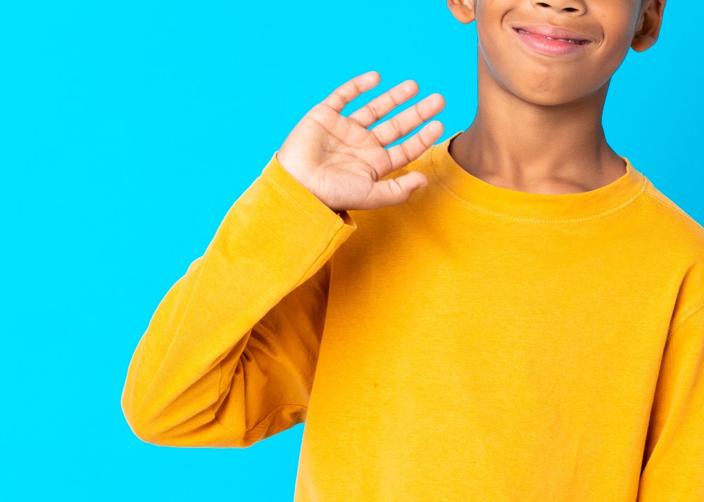 Stock photo of Black boy imitating waving motion with hand