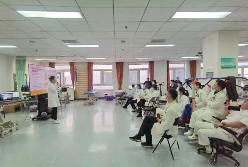 USC master’s student, Tina Peng (pictured on the left), gives a hand therapy lecture to rehabilitation therapists and hospital department chairs in the Peking University Third Hospital main gym.