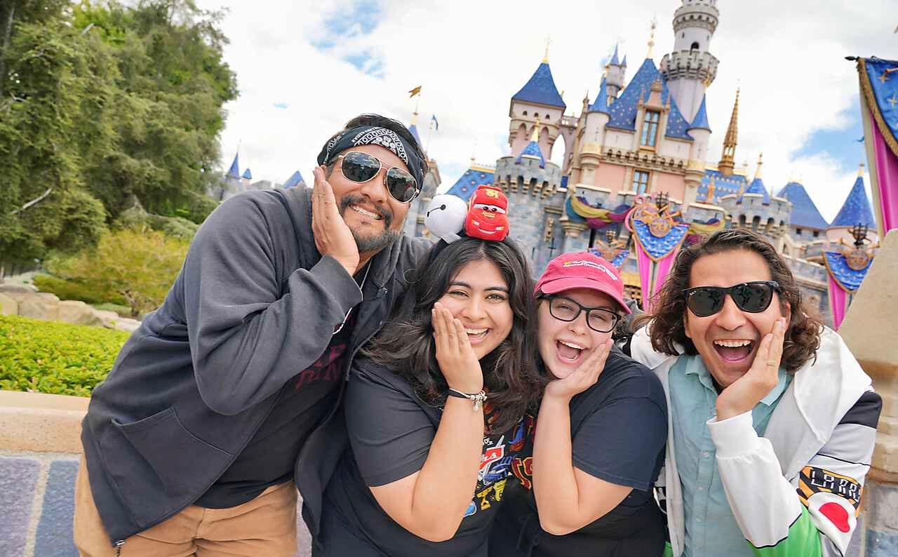 Trinity posing in front of Disneyland castle with professors and friends
