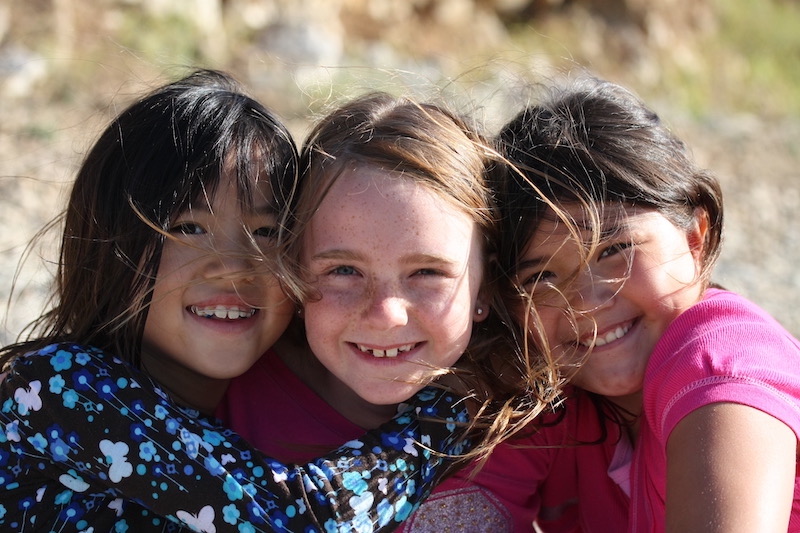 Three young girls smiling for a close up picture together