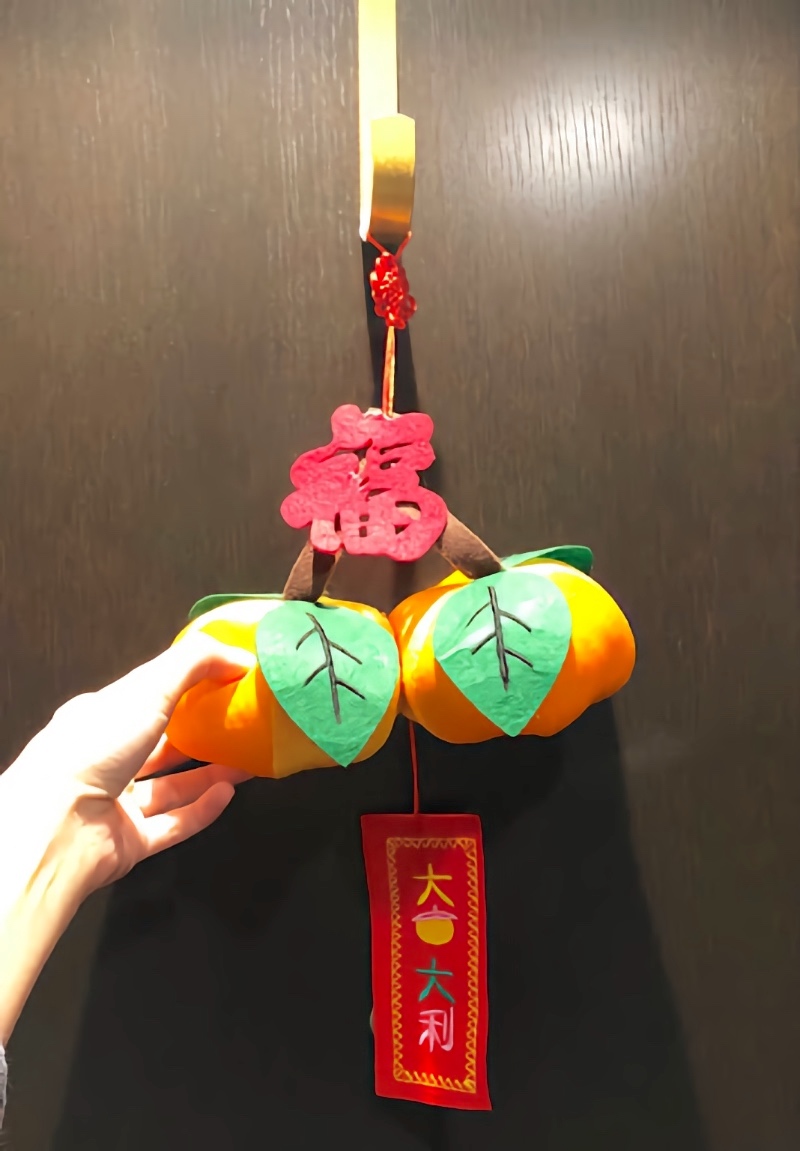 Lunar New Year decorations at the front of the door — mandarin orange plushies.