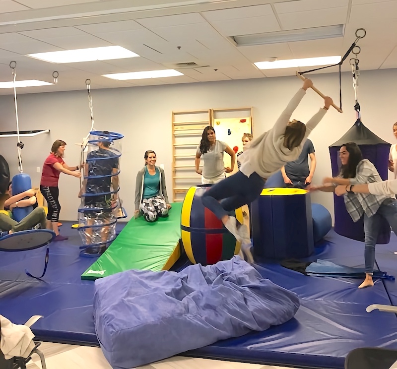 Photo of students using equipment in pediatric therapy gym