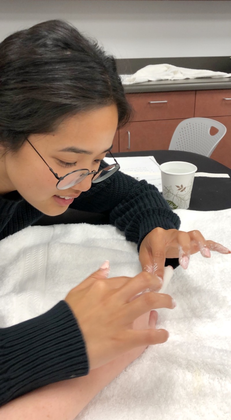 Student practicing applying a plaster digital cast