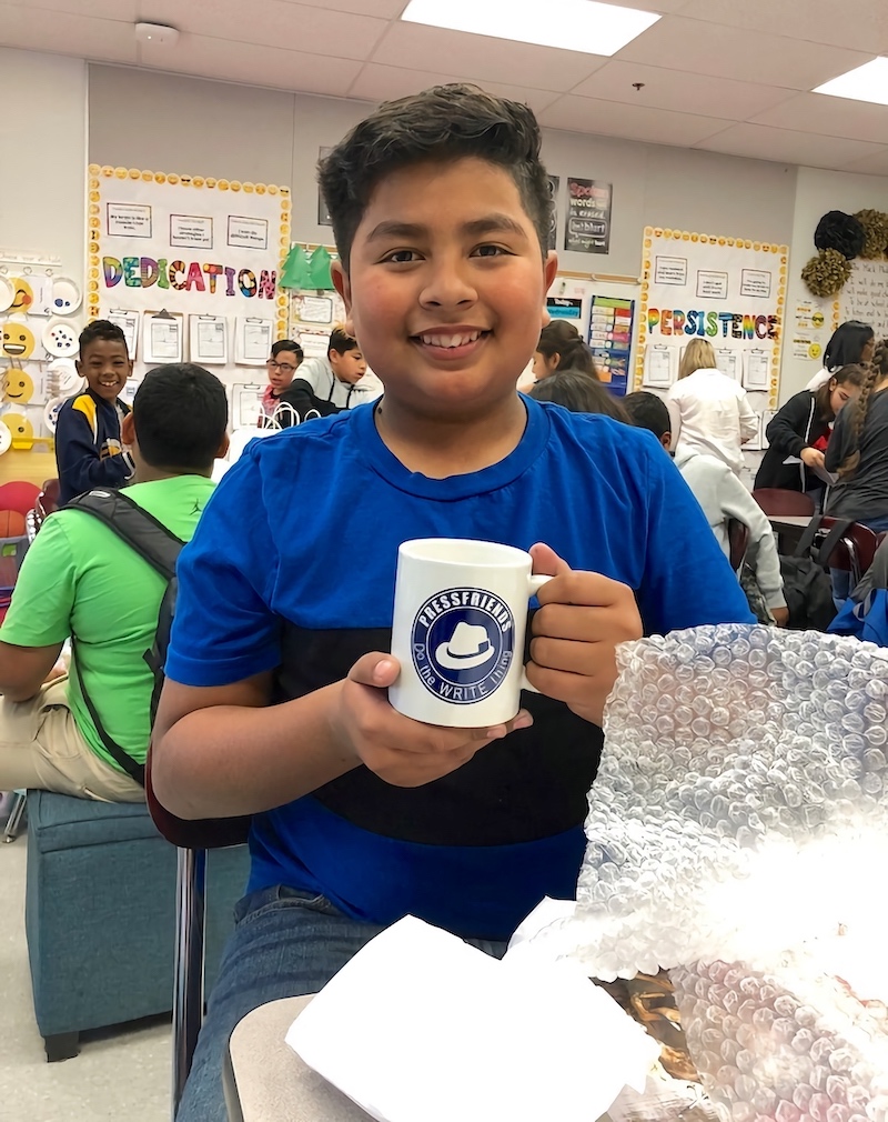 This image shows a student with a PressFriends mug