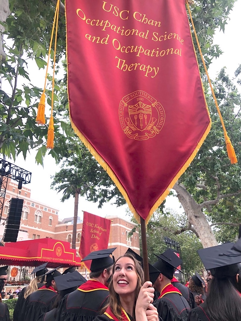 Me holding the banner at Commencement 2019