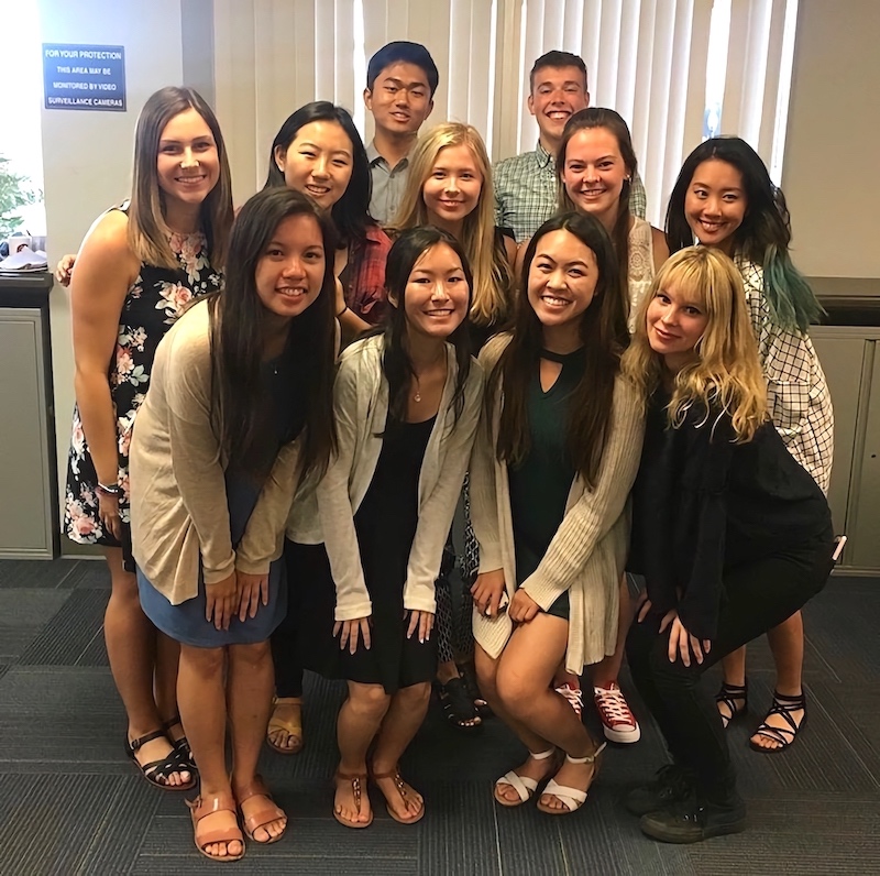 Ten bachelor's to master's students huddled together at a welcome dinner for a picture
