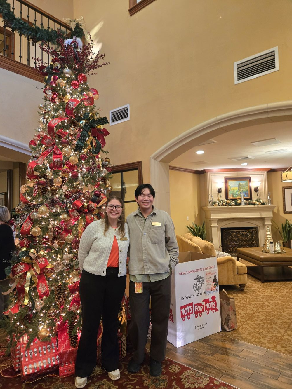 Trinity and her friend posing in front of a Christmas tree